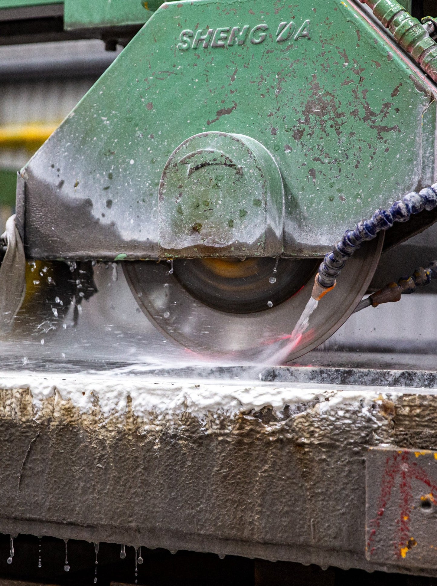 Machine cutting a slab of solid granite